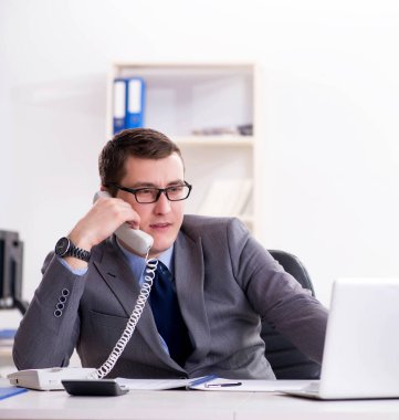 İşadamı ofis telefonundan konuşuyor.