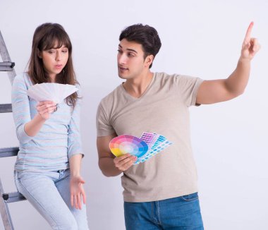 Genç bir aile evlerinde tadilat yapıyor. Duvarları boyuyor.