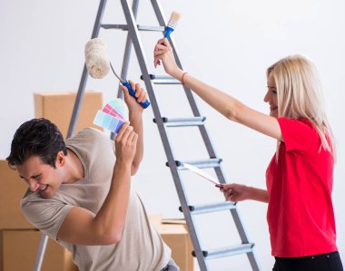 Ev tadilatı sırasında genç bir aile boya işi yapıyor.