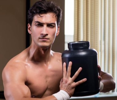 Spor salonunda besin takviyesi olan bir adam.