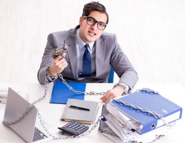 Ofis masasına zincirlenmiş meşgul bir çalışan.