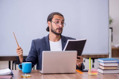 Sınıftaki genç erkek öğretmen.