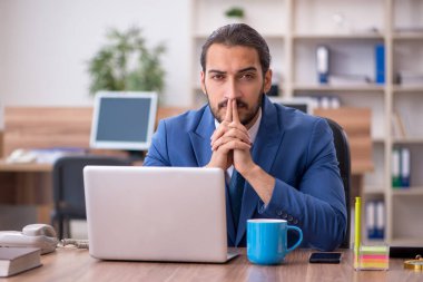 Ofiste çalışan genç bir erkek.