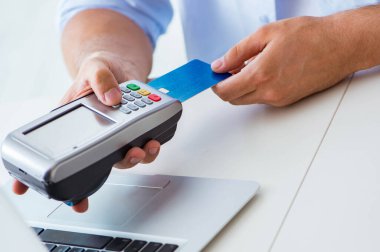 POS terminali ile kredi kartı işlemi yapan adam