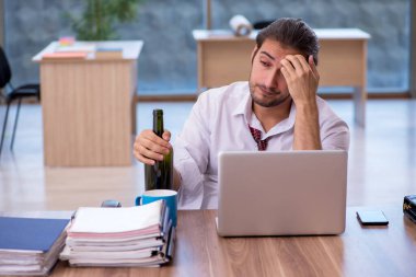 Ofiste çalışan alkol bağımlısı genç bir erkek.