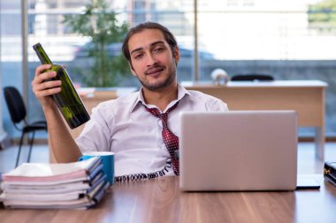 Ofiste çalışan alkol bağımlısı genç bir erkek.