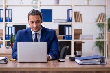 Ofiste çalışan genç bir erkek.