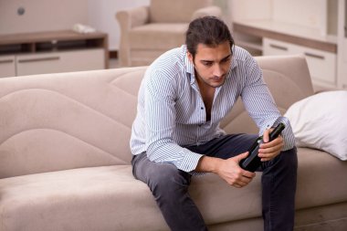 Genç sarhoş adam evde acı çekiyor.