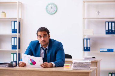 Ofiste oturan genç erkek satış analisti.