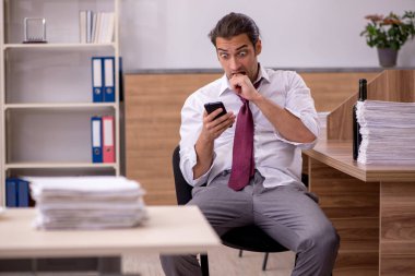 Genç erkek çalışan ofiste alkol içiyor.