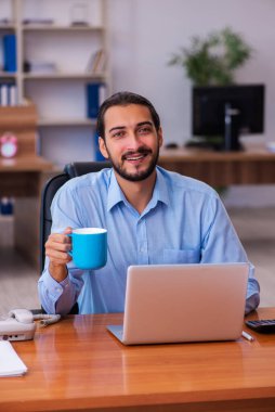 Molada çay içen genç bir erkek.