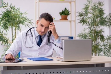 Klinikte çalışan genç erkek doktor.