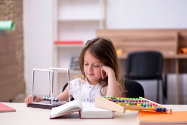 Evde sınava hazırlanan küçük kız.