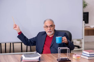 Sınıfta oturan eski bir fizikçi öğretmen.