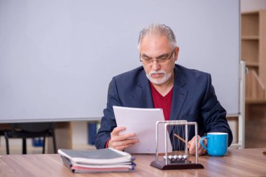 Sınıfta oturan eski bir fizikçi öğretmen.