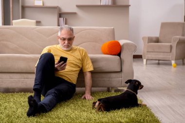 Evde köpeği olan yaşlı bir adam.