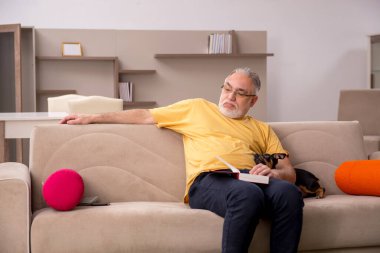 Evde köpeği olan yaşlı bir adam.