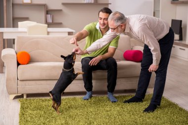 Evde köpekli iki adam.