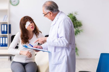 Genç kadın yaşlı erkek doktor göz doktorunu ziyaret ediyor.