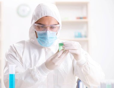 Laboratuvarda kimyasallar üzerinde çalışan genç bir kimyager.