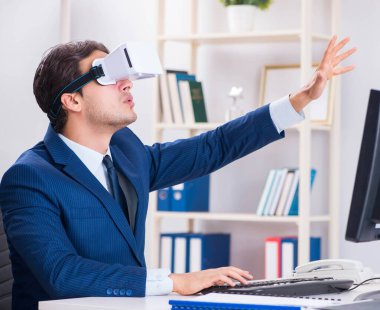 Çalışan ofiste sanal gerçeklik gözlüğü kullanıyor.