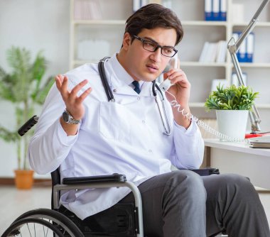 Hastanede çalışan tekerlekli sandalyedeki engelli doktor.