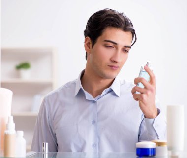 Adam banyoda çalışmak için giyiniyor.