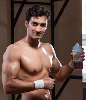 Spor salonunda besin takviyesi olan bir adam.
