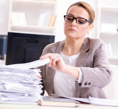 İşkadını devam eden evrak işleriyle çok meşgul.