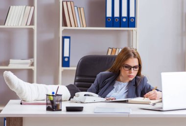 Ofiste bacağı kırık, meşgul bir çalışan.