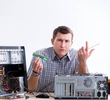 Genç teknisyen atölyede bilgisayar tamir ediyor.