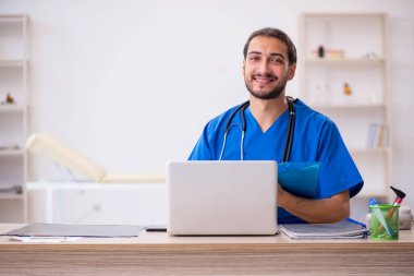 Klinikte çalışan genç erkek doktor.