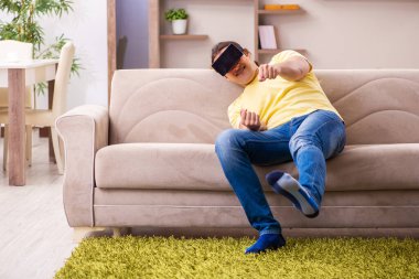 Evde sanal gözlüklü genç bir öğrenci.