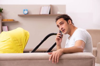 Genç erkek müteahhit evde yeni doğan çocuğa bakıyor.