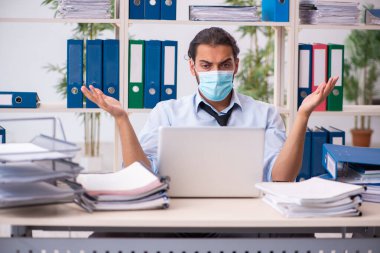 Salgın sırasında ofiste çalışan genç bir erkek.