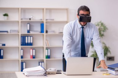 İş yerinde sanal gözlük takan genç bir erkek çalışan.