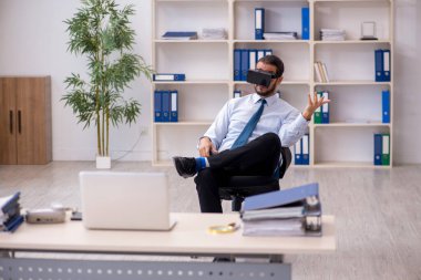 İş yerinde sanal gözlük takan genç bir erkek çalışan.