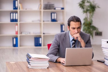 Ofisteki aşırı işten memnun olmayan genç bir erkek işçi.