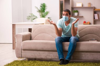 Genç adam salgın sırasında evde oturuyor.