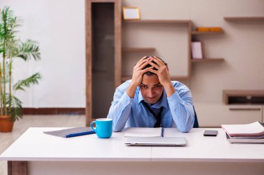 Genç erkek çalışan salgın sırasında evden çalışıyor.