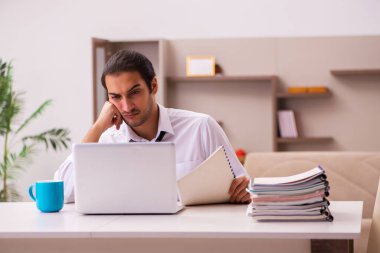 Genç erkek çalışan salgın sırasında evden çalışıyor.