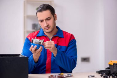 Bilgisayar tamir eden genç bir erkek tamirci.