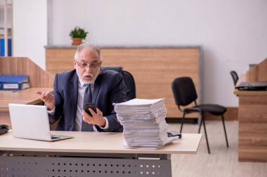 Ofisteki aşırı işten memnun olmayan yaşlı bir erkek işçi.