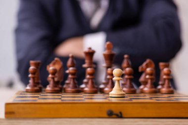 Eski erkek çalışan işyerinde satranç oynuyor