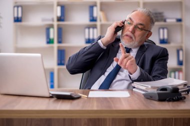 Ofiste çalışan yaşlı bir erkek.