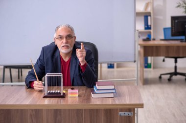 Sınıfta oturan eski bir fizikçi öğretmen.