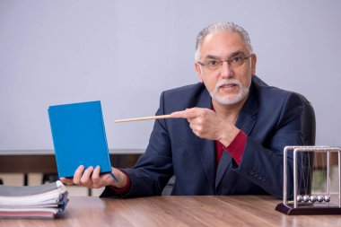 Sınıfta oturan eski bir fizikçi öğretmen.