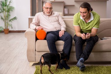 Evde köpekli iki adam.