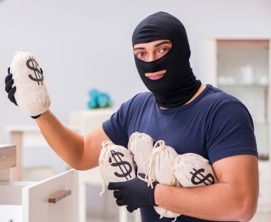 Soyguncu kar maskesi takıp değerli şeyler çalıyor.