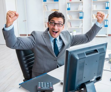 Birçok ekranın önünde oturan bir iş adamı